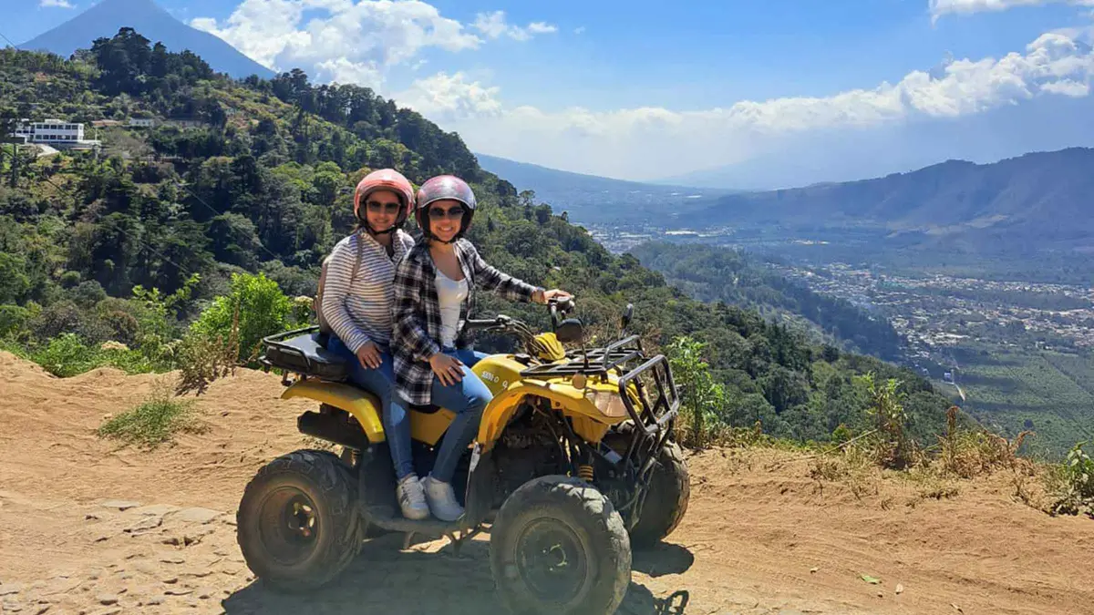 Rider on an ATV on the ridge road above the Antigua valley with Hobbitenango ahead